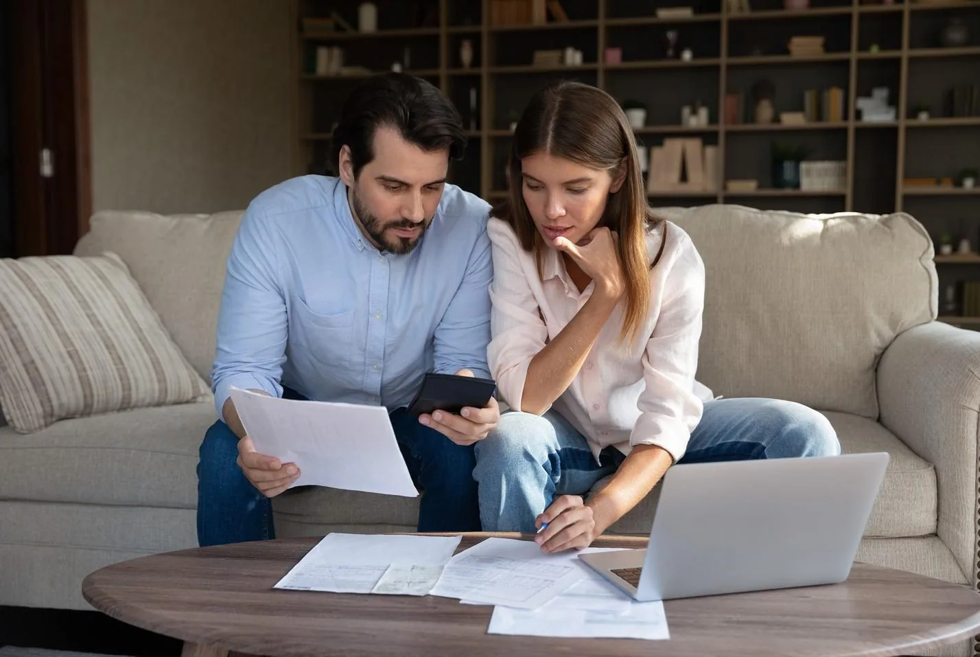 Person calculating household budget and insurance costs on a calculator